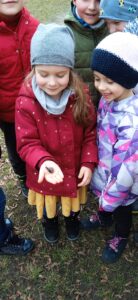 Dwie dziewczynki, jedna z nich trzyma na dłoni ślimaka.