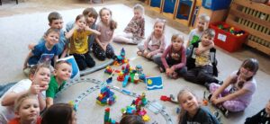 Grupa dzieci przed zbudowanymi przez siebie budowlami z klocków Lego®Eduacation "Mój świat za 100 lat"