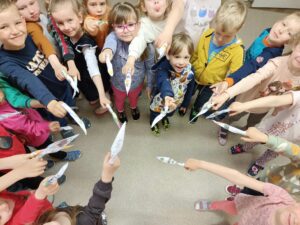 grupa dzieci stojąca w kole prezentująca ozdobne ruloniki na palce
