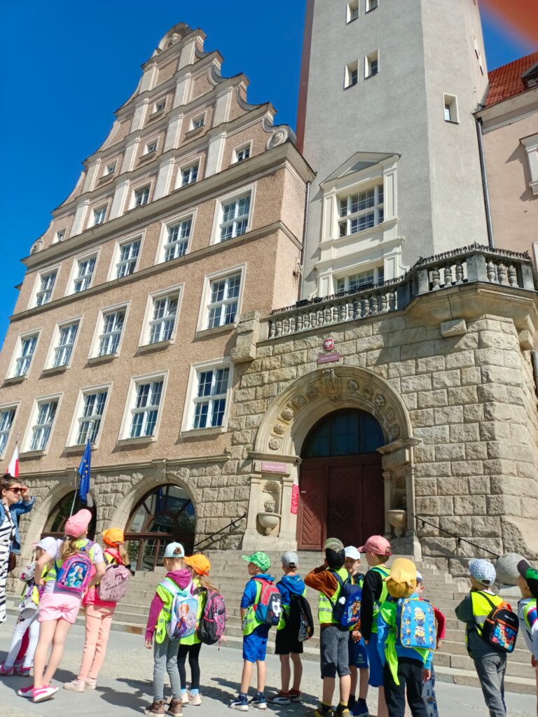Grupa dzieci spoglądająca na wieżę ratuszową w Olsztynie
