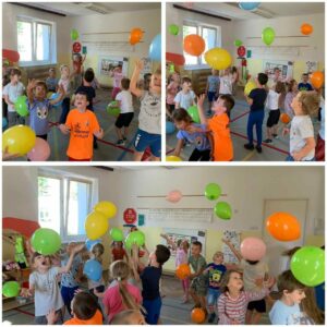 grupa dzieci odbijająca kolorowe balony