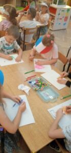 Dzieci rysujące kolorowymi kredkami.