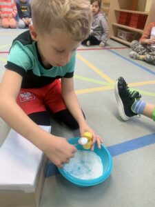 chłopiec nasypujący sól do plastikowego jajka