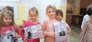 Dziewczynki trzymające fotografie przedstawiające Marię Zientarę -Malewską.