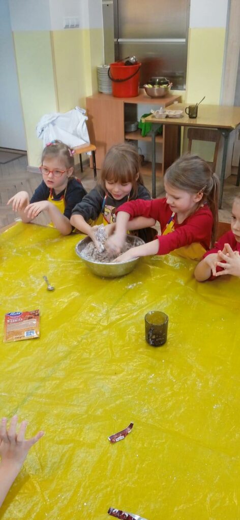 grupa dzieci ugniatająca ciasto na pierniczki