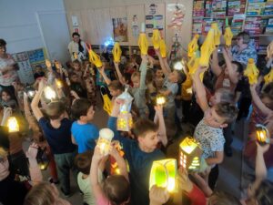 przedszkolacy trzymający wysoko latarenki