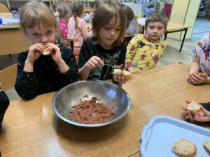 grupa dzieci jedząca wykonaną przez siebie pastę z fasoli