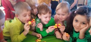 Grupa dzieci, które trzymają kaczki skonstruowane z klocków LEGO