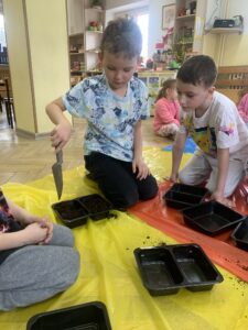 grupa dzieci siejąca rośliny