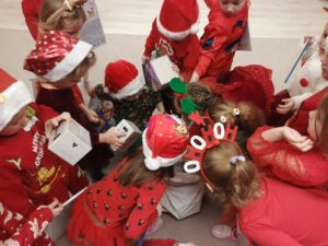 Grupa dzieci rozpakowuje prezenty.