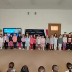 Dzieci stoją na dywanie i śpiewają hymn 5 Brygady Wileńskiej