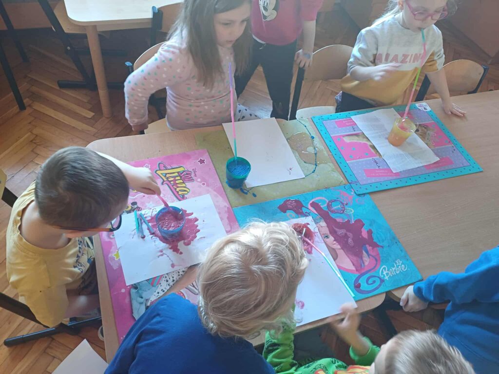 dzieci malujące za pomocą słomek