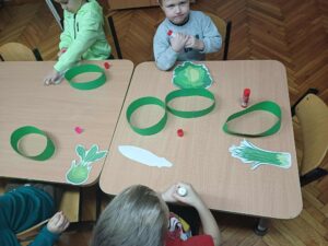 dzieci wykonują opaski z emblematem warzyw
