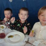 troje chłopców siedzi przy stole