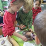 dzieci wyciskają ciasteczka za pomocą foremek