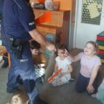 policjant wręcza odblaski dzieciom