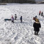 grupa dzieci biega po śniegu