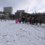 grupa dzieci stoi na górce, dokoła śnieg