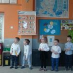 grupa przedszkolaków stoi w sali przedszkolnej