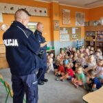 Na zdjęciu dzieci słuchające policjantów, oraz policjanci prowadzący rozmowę.