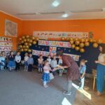 Pani Dyrektor gratuluje dziewczynce i wręcza jej upominek