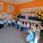 Dzieci śpiewają piosenkę stojąc w półkolu
