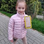 Dziewczynka pokazuje na telefonie dystans pokonany podczas spaceru