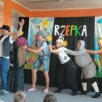 6 rodziców stoi jedno za drugim i próbuje wyrwać rzepkę