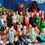 Dzieci pozują z bohaterami do grupowego zdjęcia