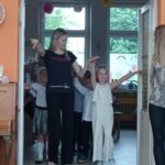 dziecko i pani instruktorką stoją w drzwiach sali