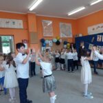 grupa dzieci tańczy na dywanie w sali