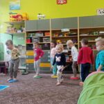 grupa dzieci bawi sie na dywanie