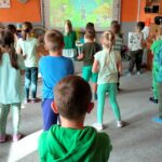 Dzieci robią rozgrzewkę powtarzają ruchy z tablicy interaktywnej