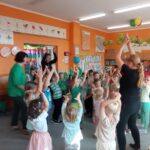 grupa dzieci podnosi ręce