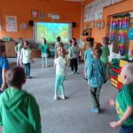 Dzieci robią rozgrzewkę powtarzają ruchy z tablicy interaktywnej