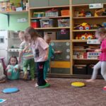 dziewczynki chodza po kolorowych dyskach