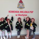 dziewczynki na tle napisu komenda straży pożarnej