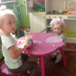 dwie dziewczynki bawią się w kąciku kuchennym