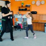 Dziewczynka wykonuje gest ochronny przed uderzeniem w głowę