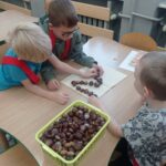 trzech chłopców układa cyfrę 2 z ksztanów