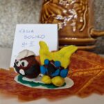 Małe ludziki z kasztanów na liściu.