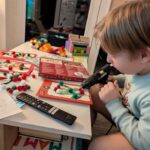 Chłopiec przykleja klejem na gorąco elementy świąteczne