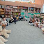 grupa dzieci siedzi w kole w sali, w rękach trzymają misie