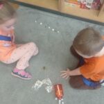 dwoje dzieci układa rytm z dostępnego materiału