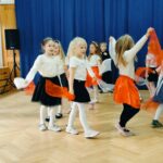 Dziewczynki tańczą w kółku z chustami