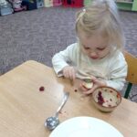 dziewczynka smaruje kanapkę dżemem