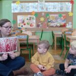 prowadząca pokazuje obrazek artystki, dzieci patrzą