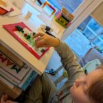 Chłopiec przykleja elementy świąteczne