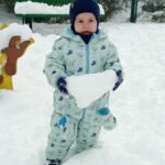 chłopiec trzyma bryłę śniegu