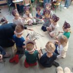 grupa dzieci przykleja paski na kartkę